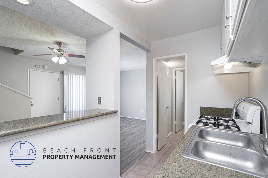 the kitchen and living room of an apartment with a stainless steel sink
